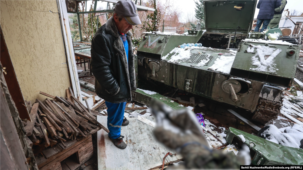 Чоловік дивиться на тіло російського солдата, що лежить біля військової машини, Буча, Київська область,1 березня 2022 року