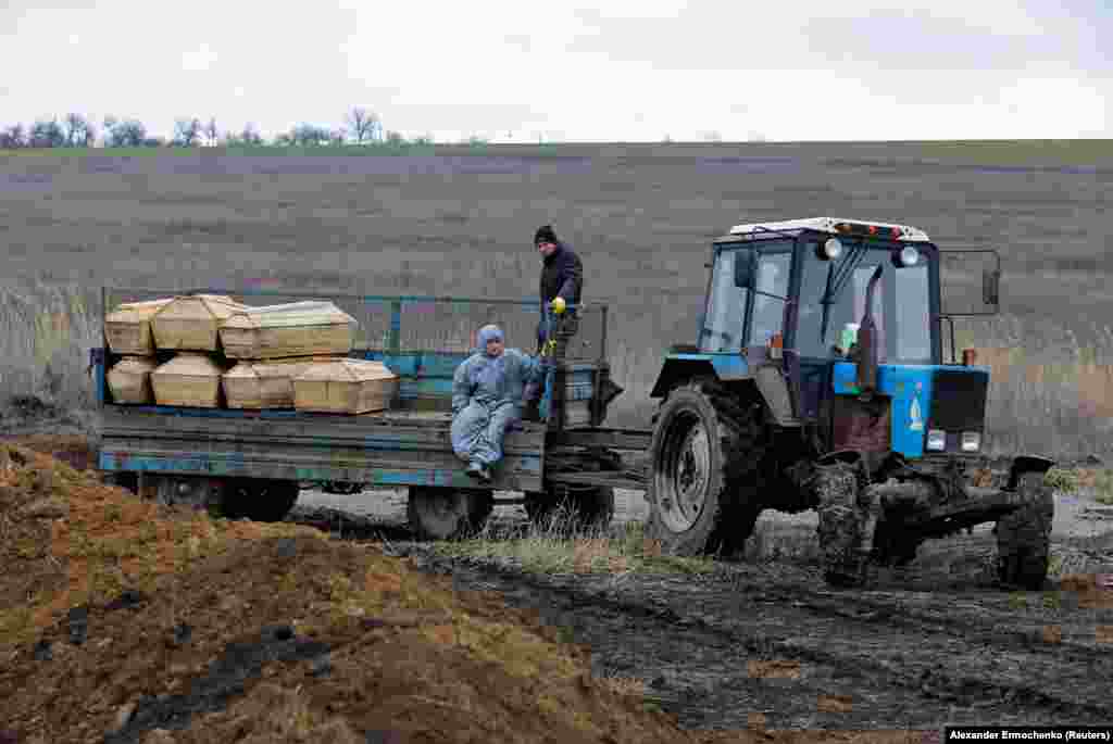 Могильники їдуть із трунами, які везуть на кладовище на околиці Маріуполя. Фото від 4 лютого 2023 року. Повідомляється, що тіла мирних жителів знаходили серед уламків будівель ще довго після закінчення російської облоги. Чимало містян ховалися від бойових дій у підвалах житлових будинків