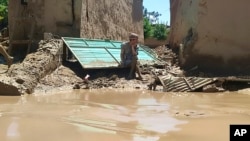 په بغلان کې سېلابونو د یوه ځايي اوسېدونکي کور نړولی او دی د پاتې شونو ننداره کوي.