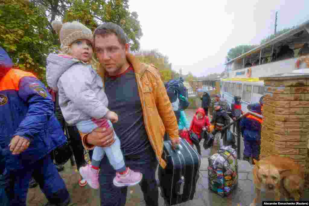 Мирные жители, эвакуированные из подконтрольного России города Херсона, идут от парома к автобусу &nbsp;