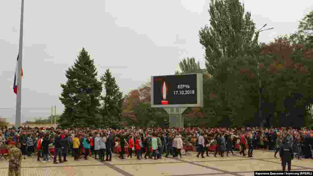 На площі Леніна стоять у ряд 17 закритих трун із тілами жертв трагедії. Поряд із кожним із них &ndash;&nbsp;фотографії й таблички з іменами загиблих. Грає жалобна музика. На великому екрані зображена свічка й напис &laquo;Керчь 17.10.2018&raquo;