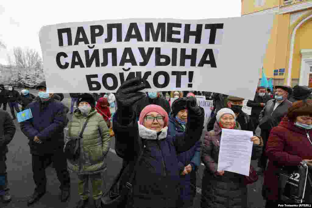 Митингіге келген әйел алдағы парламент сайлауына бойкот жариялауға шақыратын плакат ұстап тұр. Қазақстанда кезекті парламент сайлауы 2021 жылғы 10 қаңтарға белгіленген. Ол күні мәслихат сайлауы да өтеді. Белсенділер сайлаудың бұрмаланатынын, оның билік партиясы &quot;Нұр Отан&quot; жеңіп шығатындай етіп ұйымдастырылатынын айтады. Қазақстандағы осыған дейінгі парламенттік сайлаулар жөнінде мына жерден оқысаңыз болады.