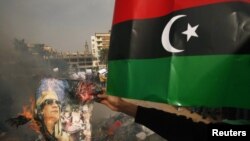 Libya -- Protesters burn pictures of Libyan leader Muammar Qaddafi and copies of the Green book, in Benghazi, 02Mar2011