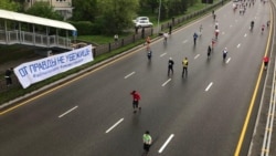 Марафон өтіп жатқан жолдың бойына ілінген, "Шындықтан қашып құтылмайсың" деген жазу бар баннер. Алматы, 21 сәуір 2019 жыл.