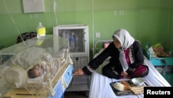 Afghanistan -- A woman takes care of her newborn baby at Cure International's hospital in Kabul, 08May2012