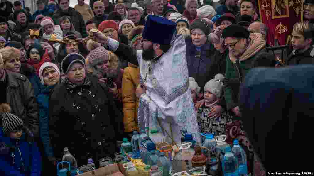 Жителі міста з дітьми під час молитви біля причалу