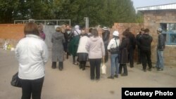 Павлодар түрмесінде отырған туыстарымен кездесуді талап етіп, түрме қақпасы алдында тұрған адамдар. (Көрнекі сурет.)