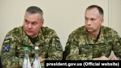 Колишній командувач операції Об'єднаних сил (ООС) ЗСУ Сергій Наєв (ліворуч) і новий командувач Об'єднаними силами генерал-лейтенант Олександр Сирський. Донеччина, 6 травня 2019 року