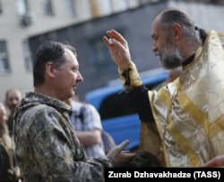 Священик благословляє російського полковника Ігоря Гіркіна (Стрєлкова), який на той час був одним із ватажків угруповання «ДНР», що визнане в Україні терористичним. Окупований Донецьк, 10 липня 2014 року