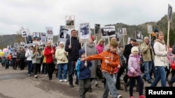 "Мәңгі өлмес полк" шеруіне шығарылған ресейлік мектеп оқушылары. Көрнекі сурет