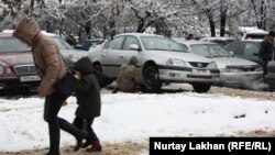 Алматы тұрғыны көлігінің дөңгелегін ауыстырып жатыр. (Көрнекі сурет)