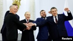 Президент Росії Володимир Путін і Денис Пушилін, Леонід Пасечник, Володимир Сальдо, Євген Балицький, яких призначили керувати частинами окупованих Донецької, Луганської, Херсонської та Запорізької областей України, на церемонії проголошення анексії цих територій у Кремлі