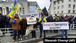 Люди стоять перед військовими Росії під час мітингу проти російської окупації. Херсон, 13 березня 2022 року