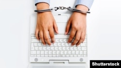 Generic -- Female hands in handcuffs with laptop. Internet censorship. (©Shutterstock)